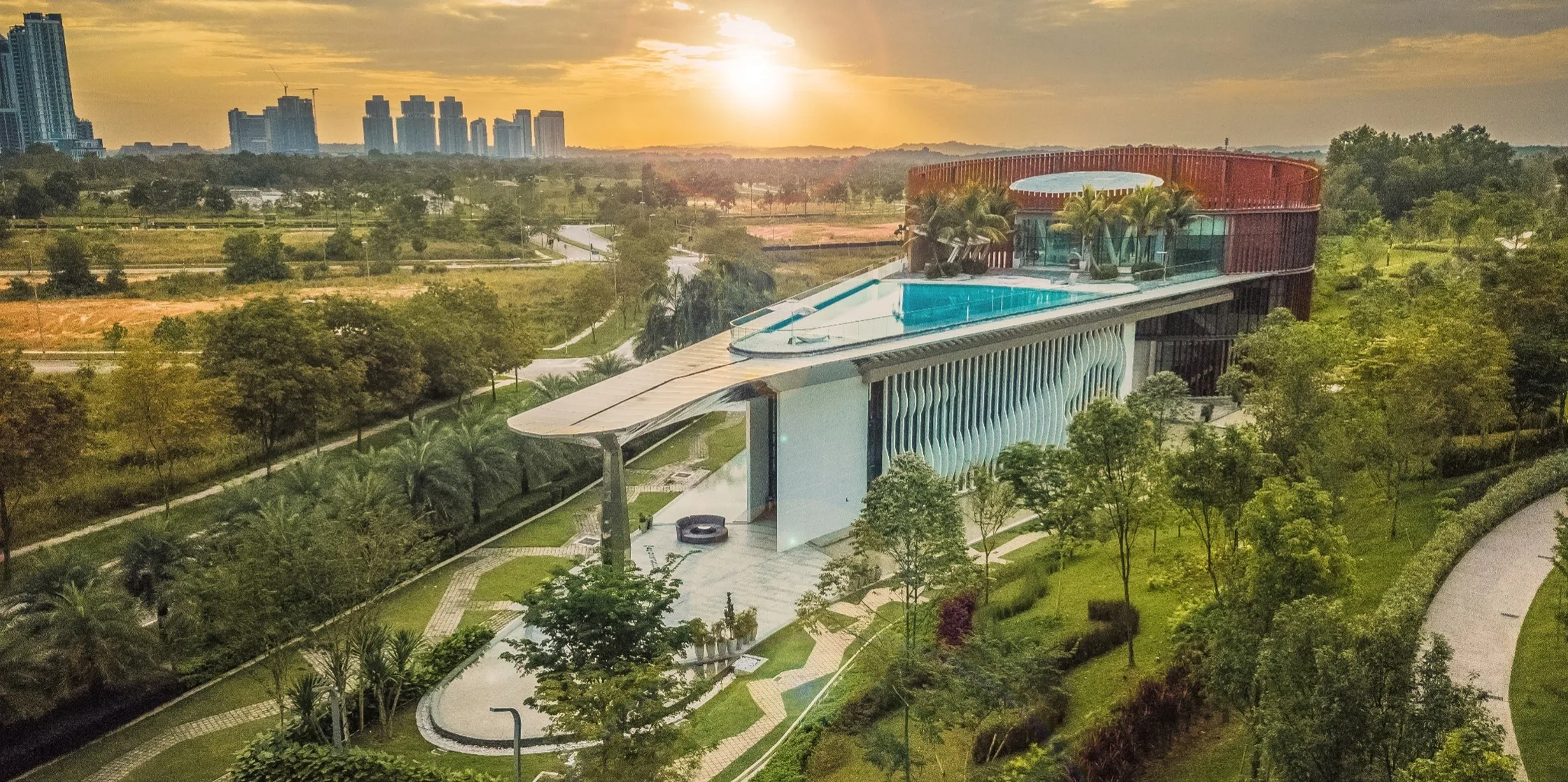 Aerial view at sunset of the clubhouse, rooftop pool and park at Macrolink Medini Central Park